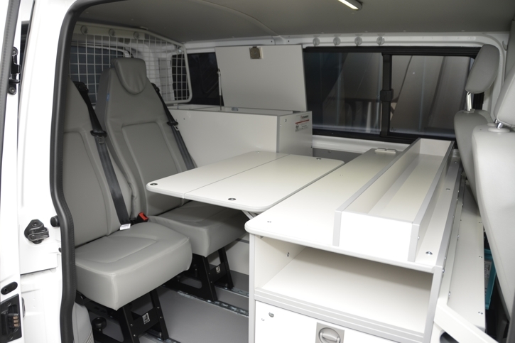 Two workstations with single seats, folding table and a large work surface 
